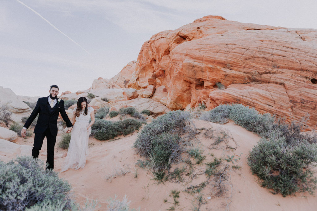 valley of fire wedding photos bride and groom walking in desert
